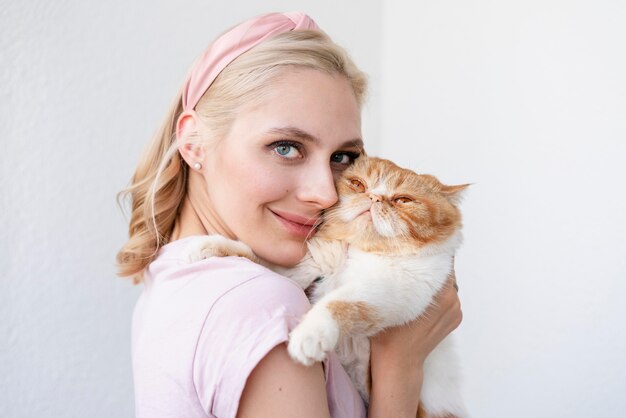 Cerrar mujer sosteniendo gato soñoliento