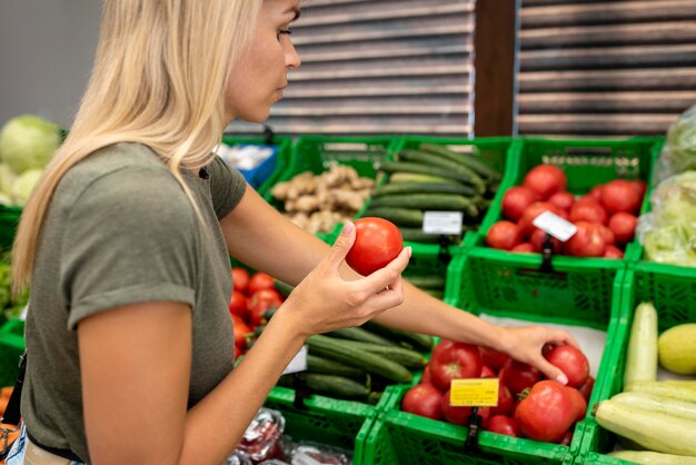 Cerrar mujer sosteniendo tomate