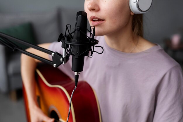 Cerrar mujer tocando la guitarra y cantando