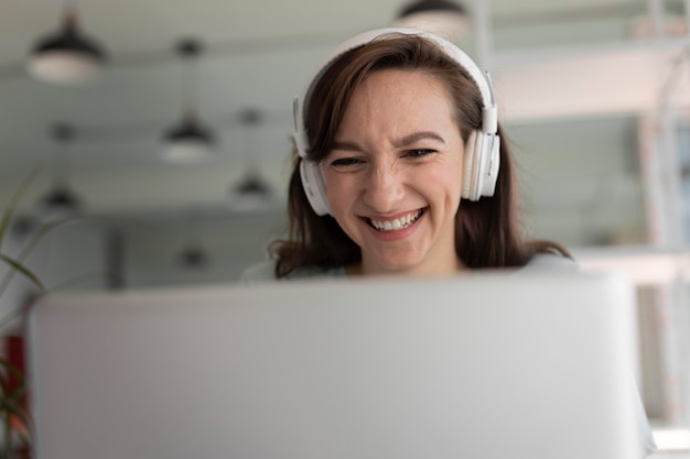 Cerrar mujer trabajando con auriculares