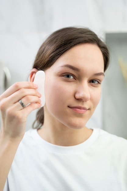 Cerrar mujer usando gua sha