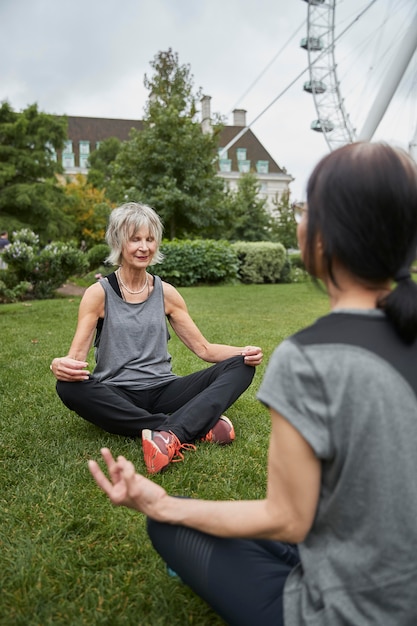 Cerrar mujeres meditando al aire libre