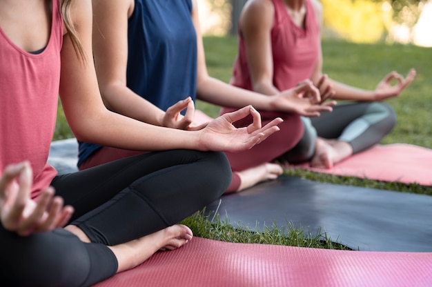 Cerrar mujeres meditando juntos