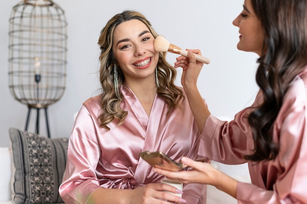 Cerrar mujeres poniéndose maquillaje