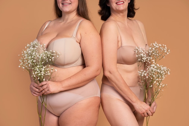 Cerrar mujeres sonrientes posando con flores