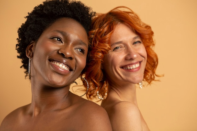 Foto gratuita cerrar mujeres sonrientes posando juntos