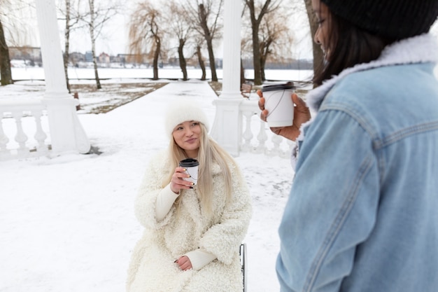 Cerrar mujeres sonrientes con tazas de café