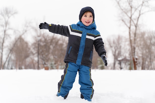 Foto gratuita cerrar n niño feliz jugando en la nieve.