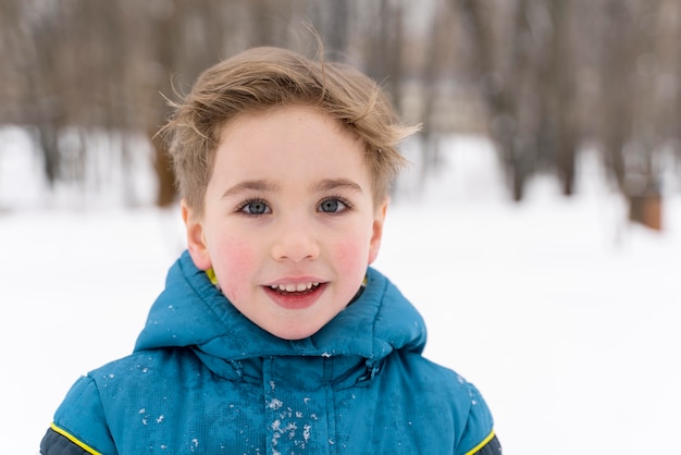 Cerrar n niño feliz jugando en la nieve.