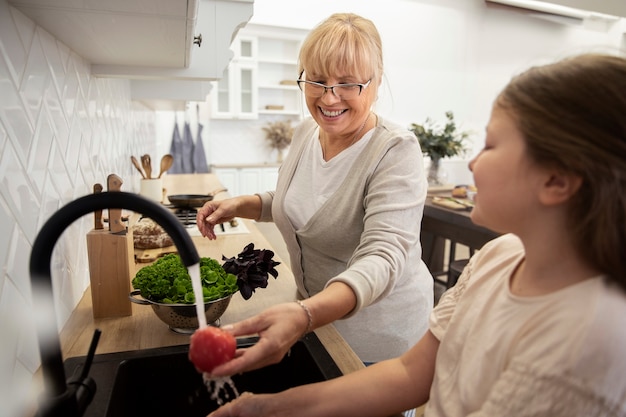 Cerrar niña y abuela en la cocina