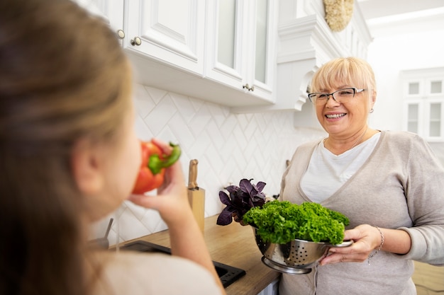 Cerrar niña y abuela sonriente con comida