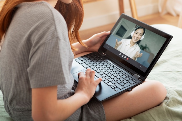 Cerrar niña aprendiendo con laptop en interiores