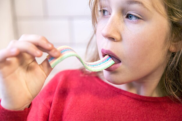 Cerrar niña comiendo caramelos gomosos