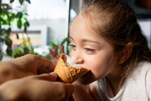 Foto gratuita cerrar niña comiendo helado