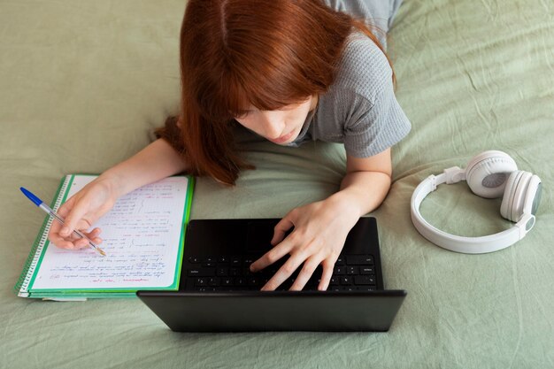 Cerrar niña estudiando con laptop