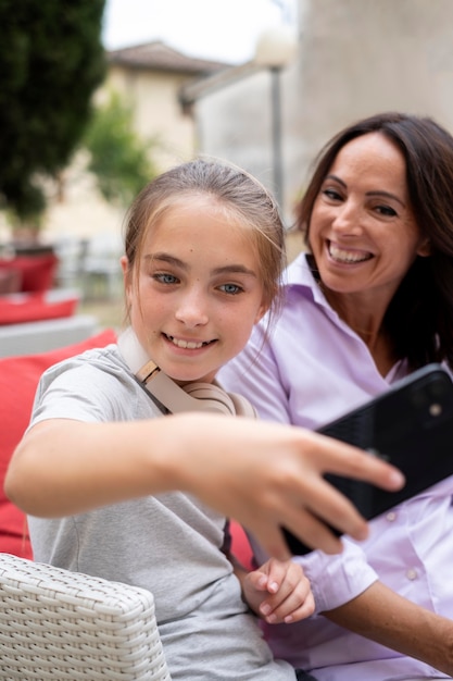 Cerrar niña y mujer tomando selfie