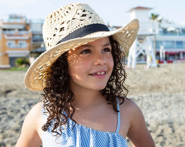 Cerrar niña con sombrero en la playa