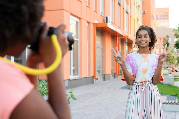 Foto gratuita cerrar niña sonriente posando al aire libre