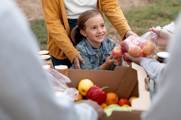 Cerrar niña sonriente recibiendo manzanas