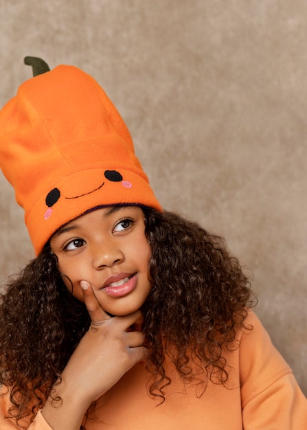 Cerrar niña sonriente con sombrero de calabaza