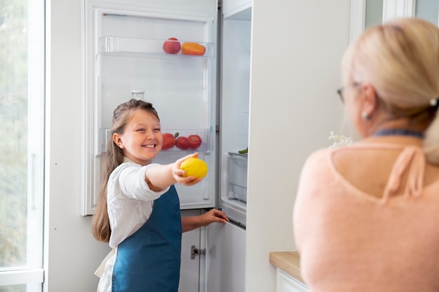 Cerrar niña sonriente sosteniendo limón