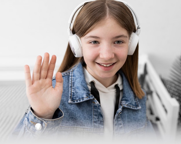 Foto gratuita cerrar niña sonriente usando audífonos