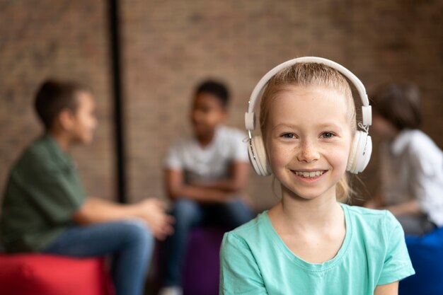 Cerrar niña sonriente usando audífonos