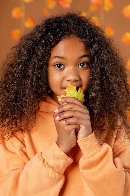 Foto gratuita cerrar niña sosteniendo la hoja