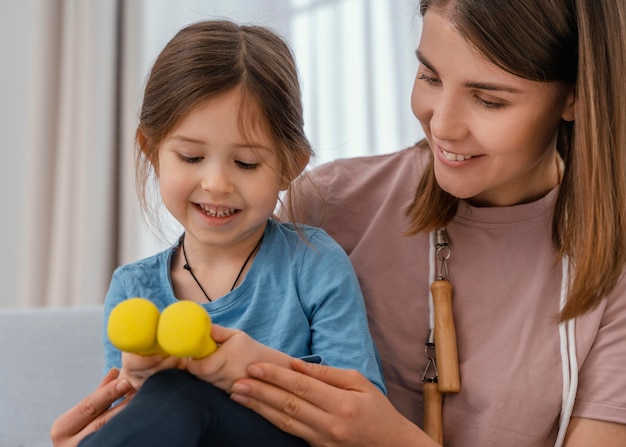 Cerrar niña sosteniendo pesas