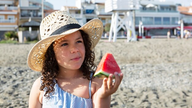 Cerrar niña sosteniendo una rebanada de sandía