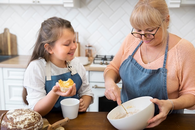 Cerrar niña viendo mujer cocinar