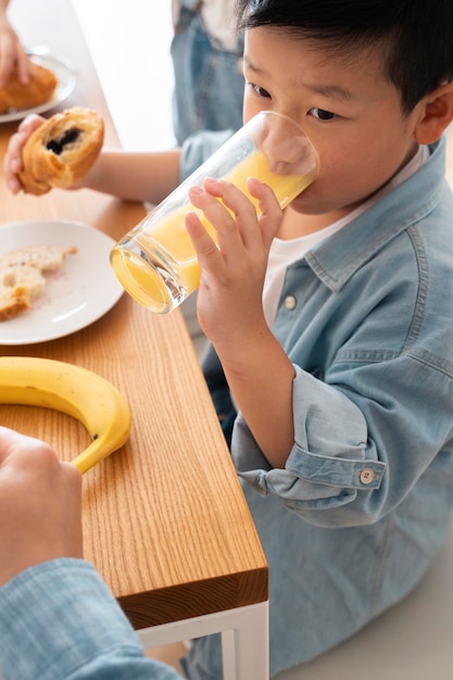 Foto gratuita cerrar niño bebiendo jugo