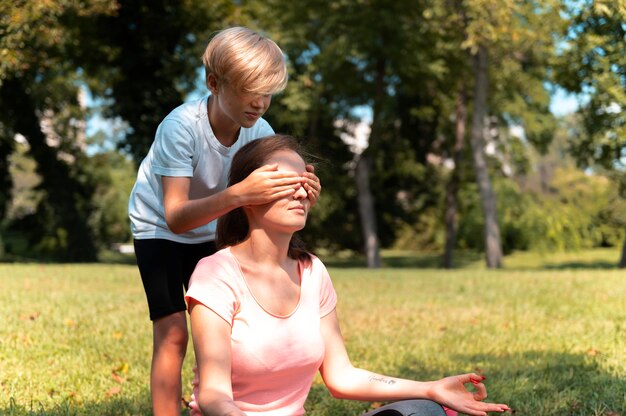 Cerrar niño cubriendo los ojos de la mujer