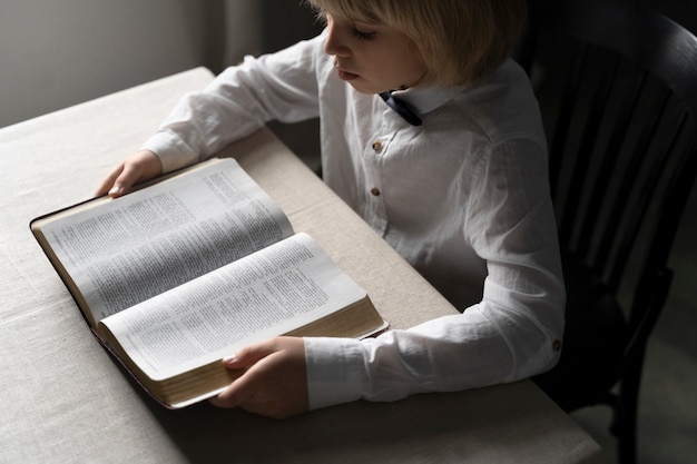 Cerrar niño leyendo la biblia
