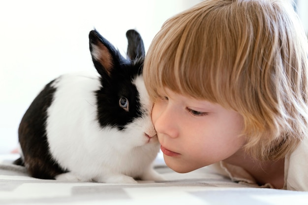 Foto gratuita cerrar niño con lindo conejo