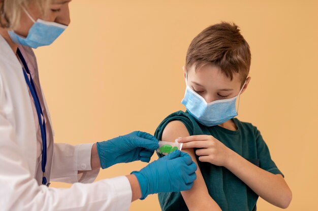 Cerrar niño y médico con máscaras