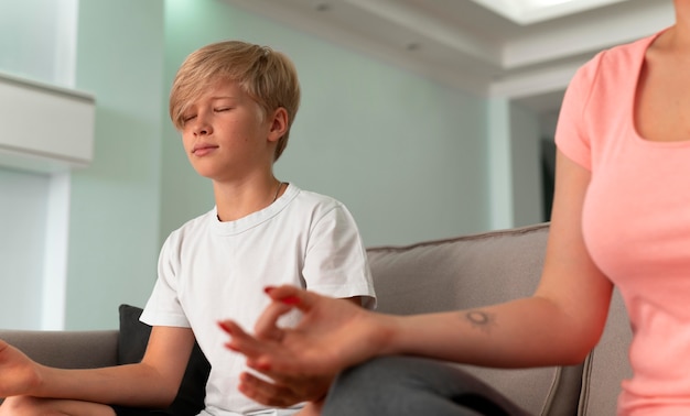 Cerrar niño y mujer meditando