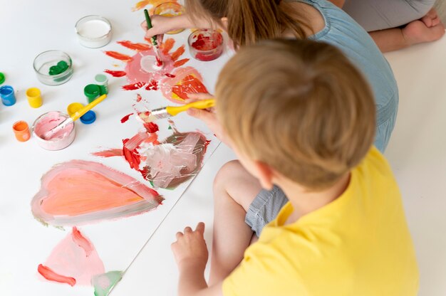 Cerrar niño y niña pintando juntos