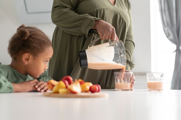 Cerrar niño sentado a la mesa con comida