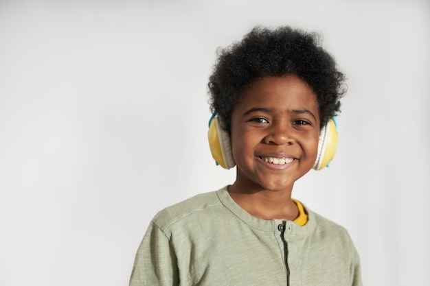 Cerrar niño sonriente con auriculares