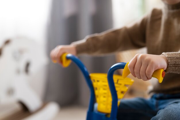 Cerrar niño sosteniendo manillar de triciclo