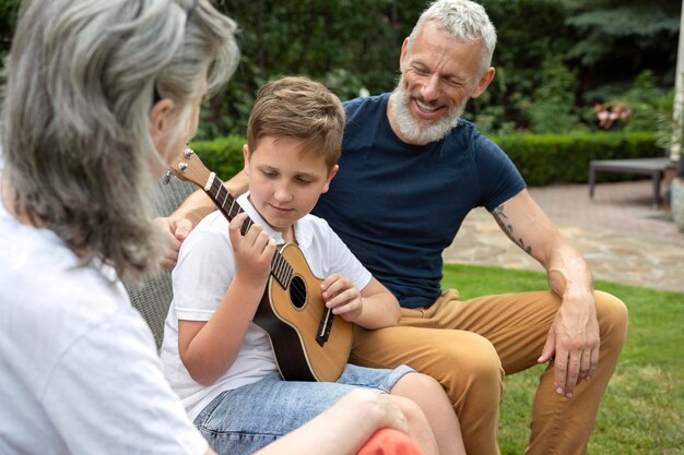 Cerrar niño tocando música para abuelos