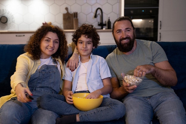 Foto gratuita cerrar el niño viendo películas con los padres