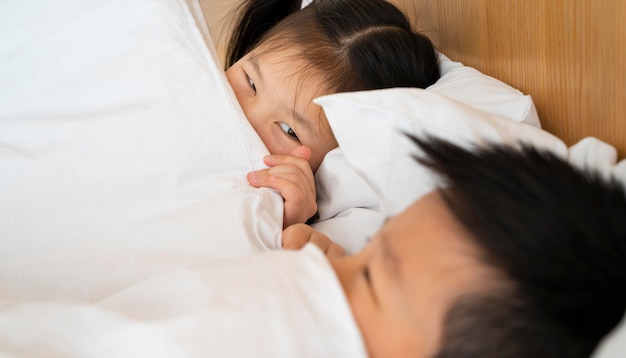 Foto gratuita cerrar niños acostados en la cama