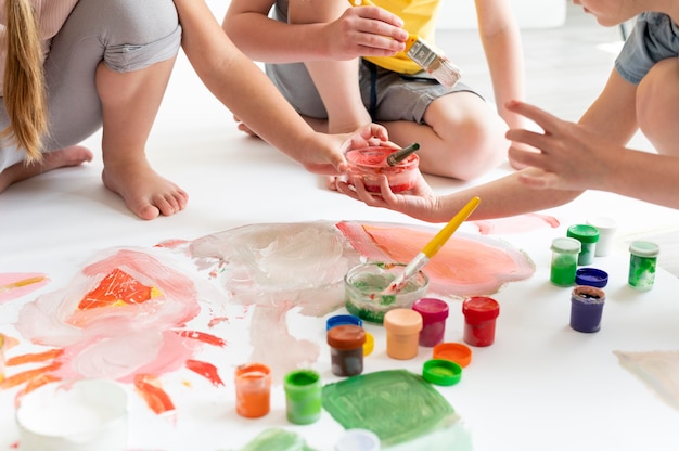 Cerrar niños pintando como equipo