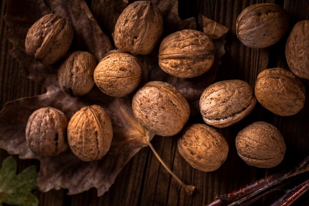 Cerrar nueces en mesa de madera con hojas