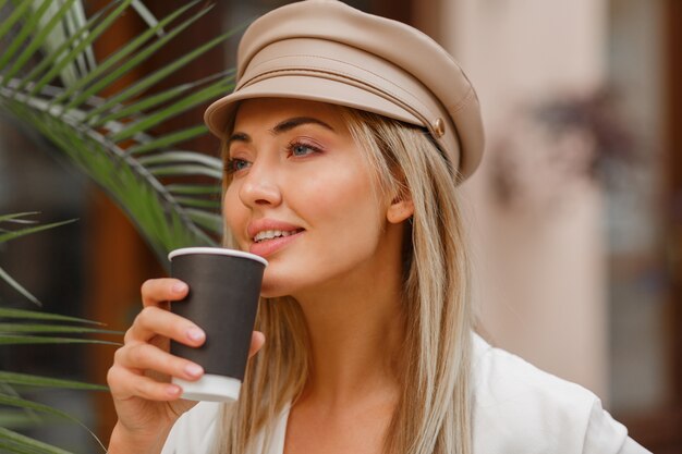 Cerrar otoño retrato de mujer rubia romántica disfrutando de un café caliente al aire libre