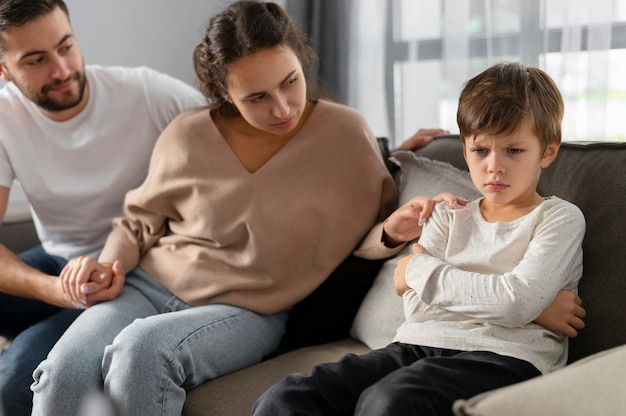 Cerrar a los padres y al niño triste en la terapia