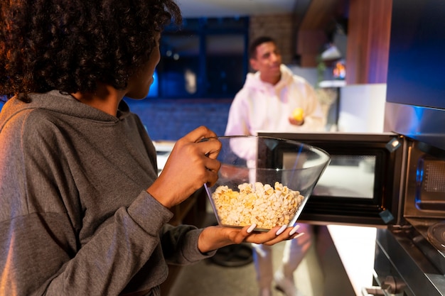 Foto gratuita cerrar pareja con palomitas de maíz en casa