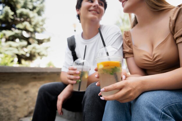 Cerrar pareja sonriente con bebidas